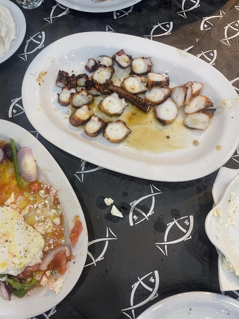 Ολόκληρο ψητό ψάρι σε πιατέλα με λεμόνι και λαχανικά.